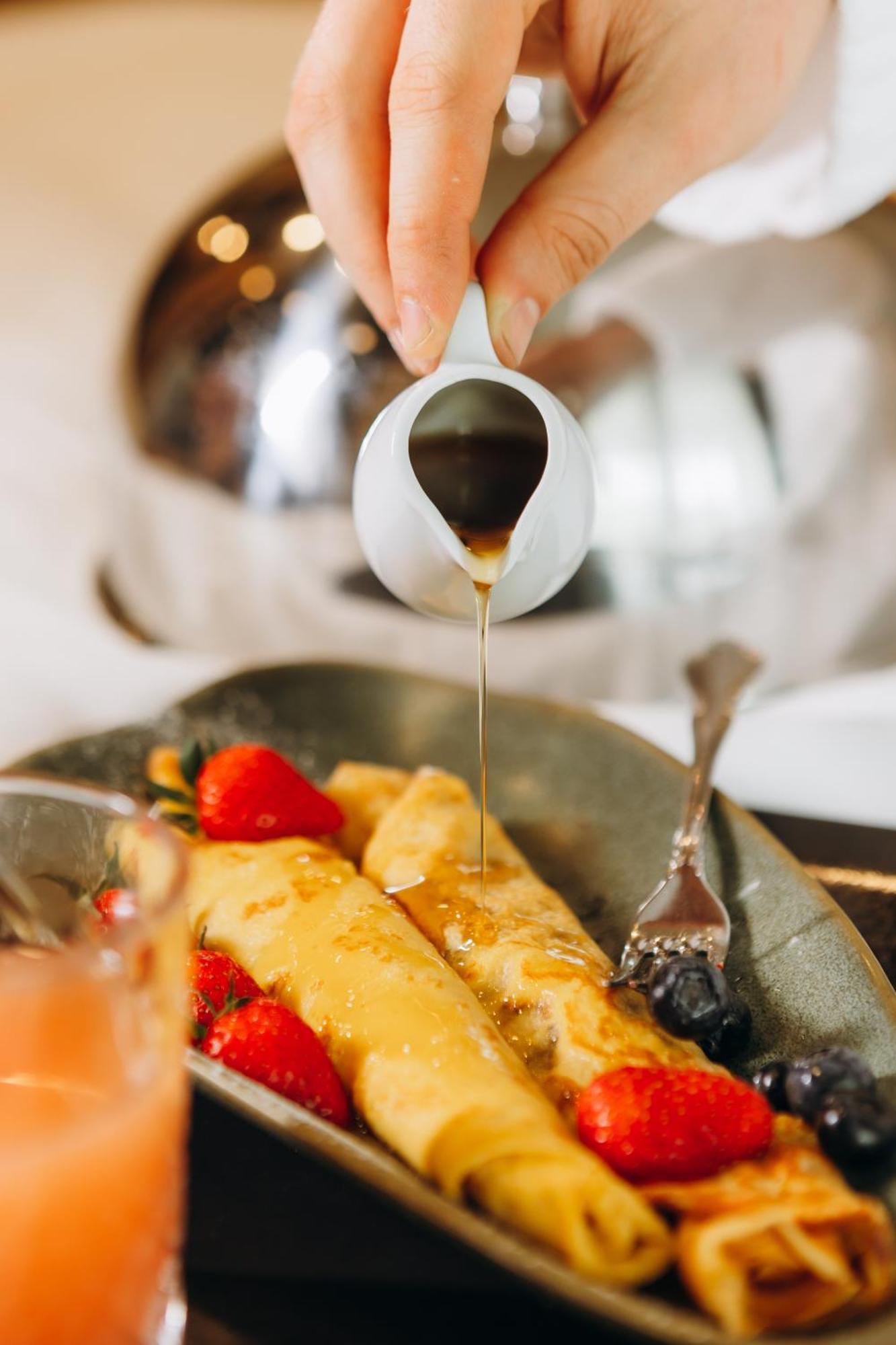 Hotel Platinia Kluž Exteriér fotografie Maple syrup being poured onto crêpes